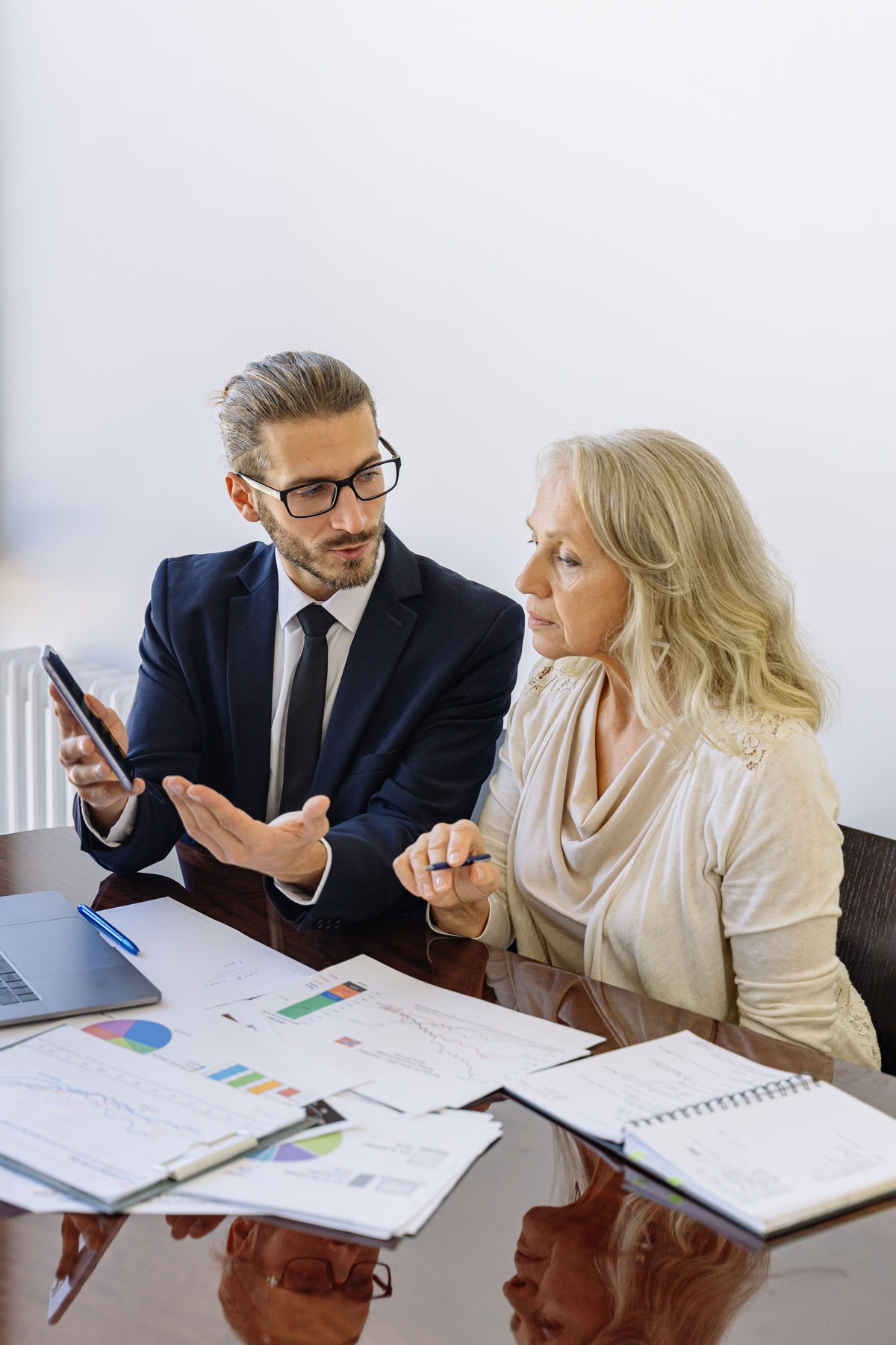 Underwriter reviewing bank statements with a business owner at a desk