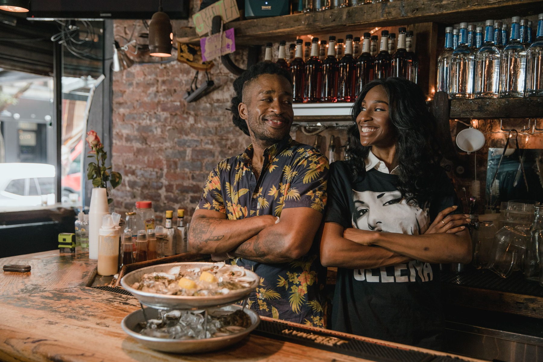 Two small-business owners standing together behind their counter